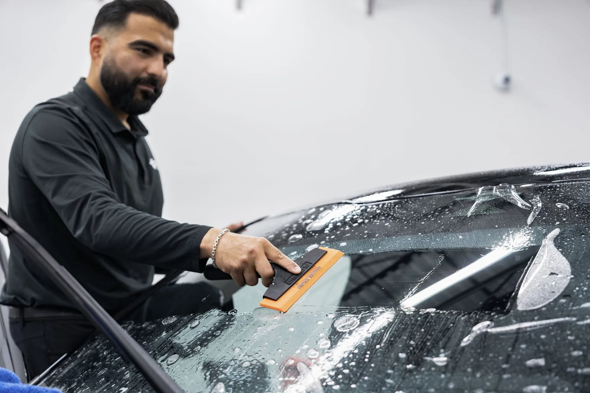 Nash installer applying film to a windshield